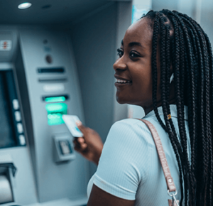 Young woman using ATM