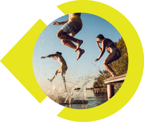 Three people in bathing suits jumping off desk into the lake.