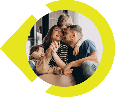 Family of four hanging on one another and smiling.