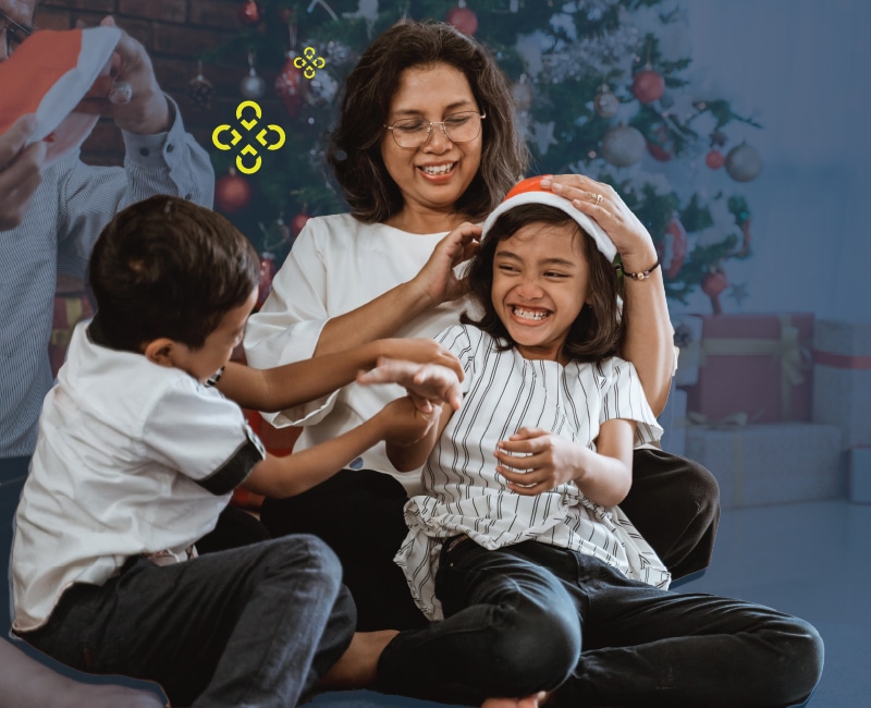 A family of three joyfully plays, with festive decor in the background. Text reads, "Gift Yourself the Gift of PEACE" promoting holiday savings at Vicinity Credit Union.