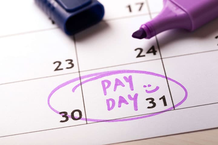 Pay day reminder written on calendar with highlighter